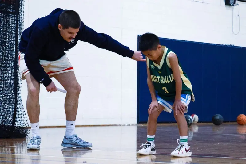A coach helping a young player get into position