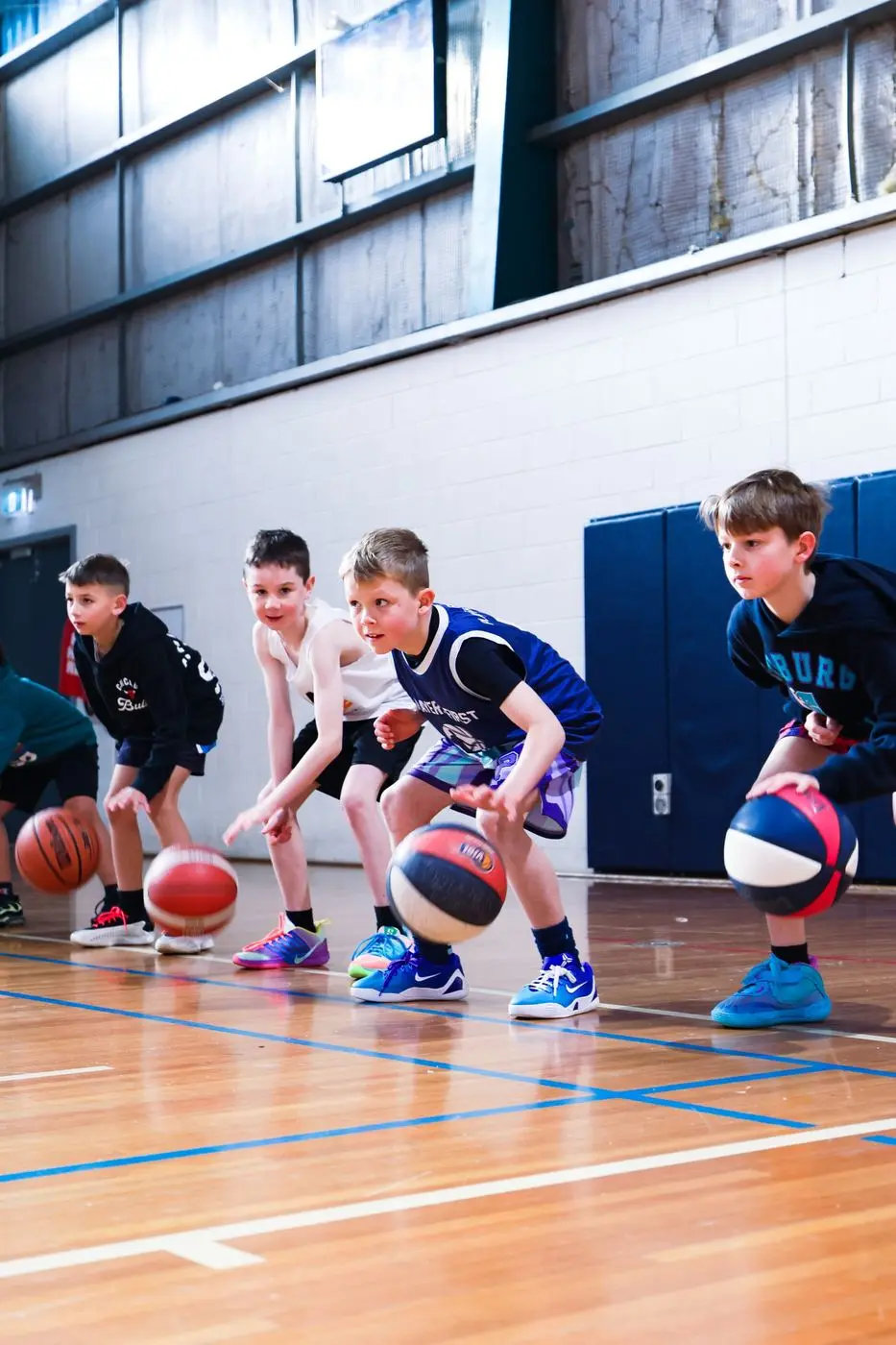 A line of kids dribbling basketballs at training